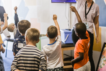 Children raising hands in Children's Church