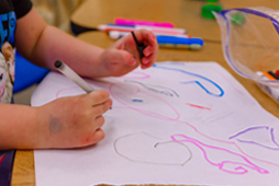 Child's hands drawing on paper
